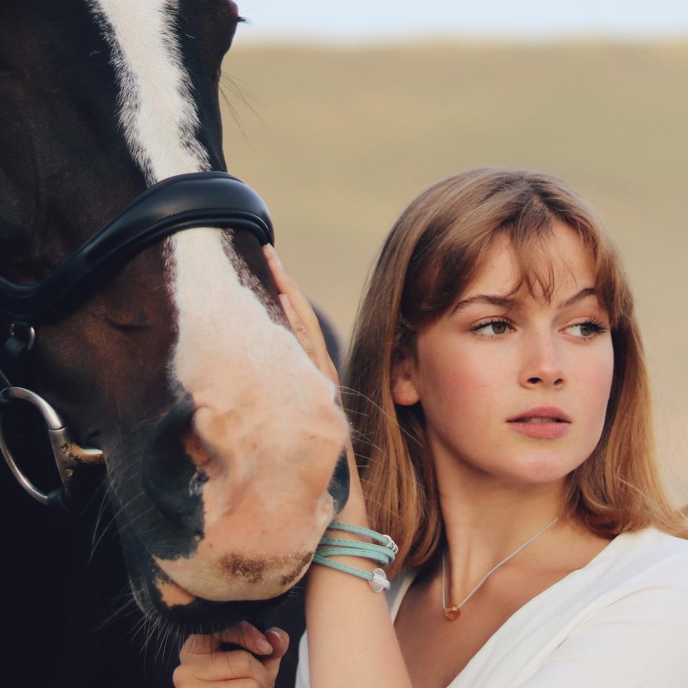 Woman with a horse at the beach.