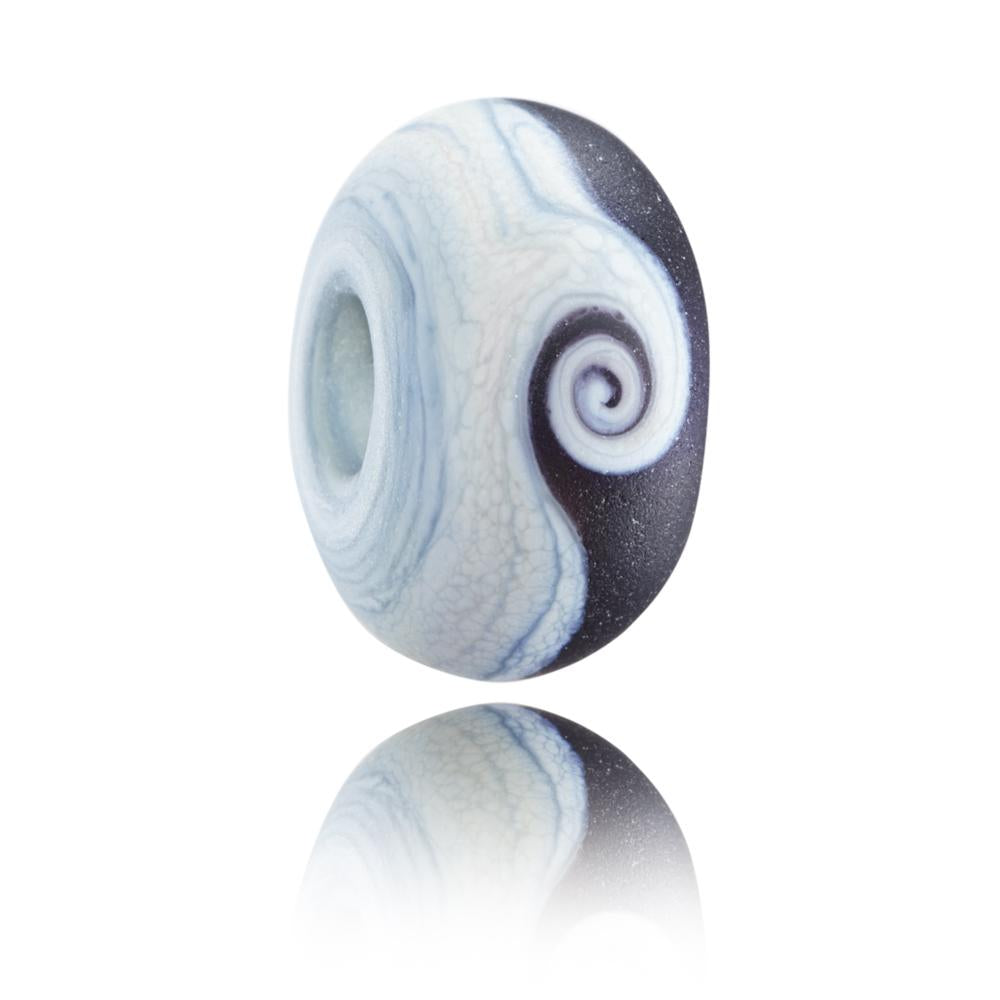 Grey and black glass bead with a swirl in the middle representing Lynmouth in North Devon.