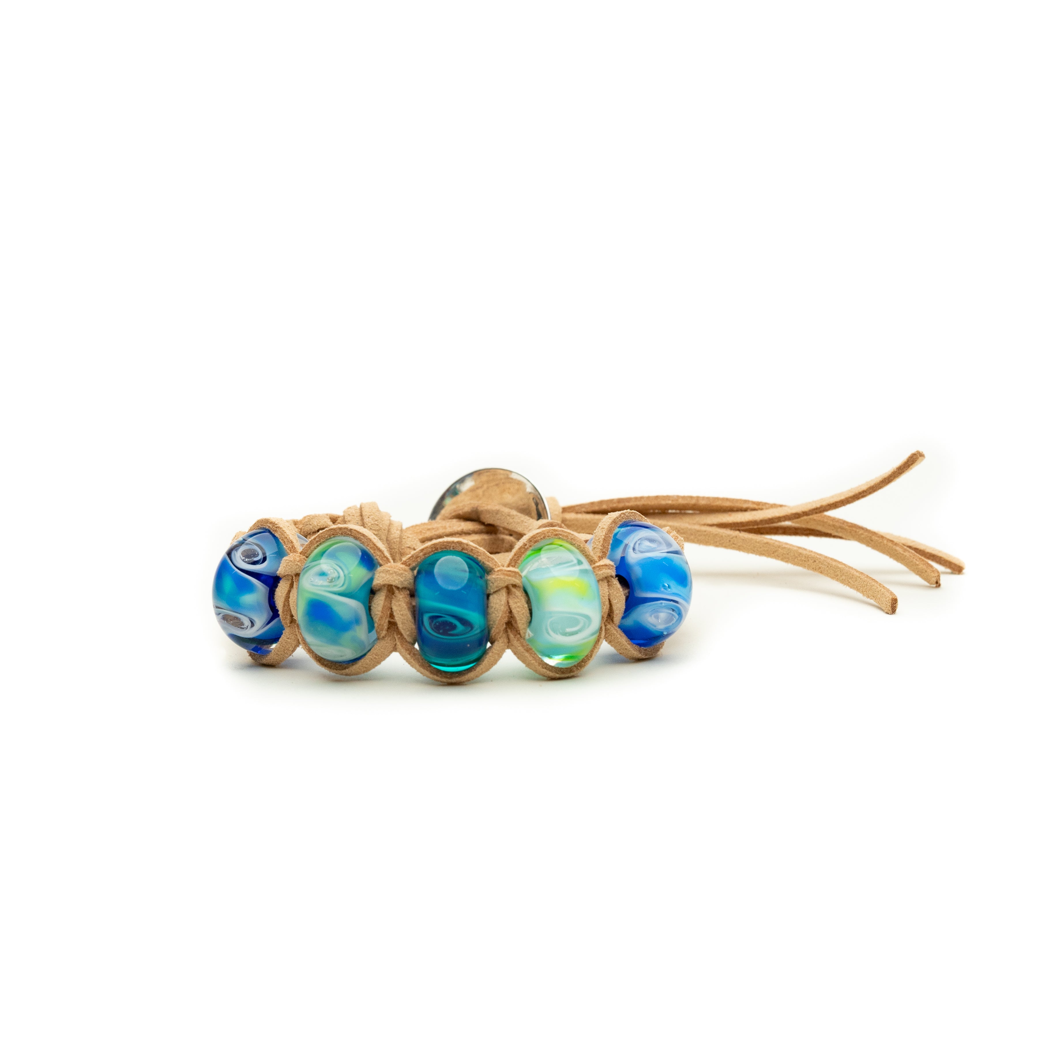 Ocean inspired swirling glass beads on sand cord surfer style bracelet.