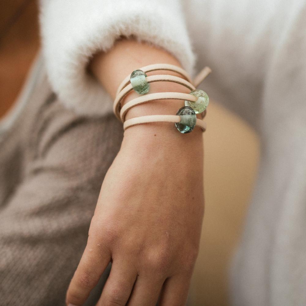 Person wearing Sand leather wrap bracelet with glass sand beads.