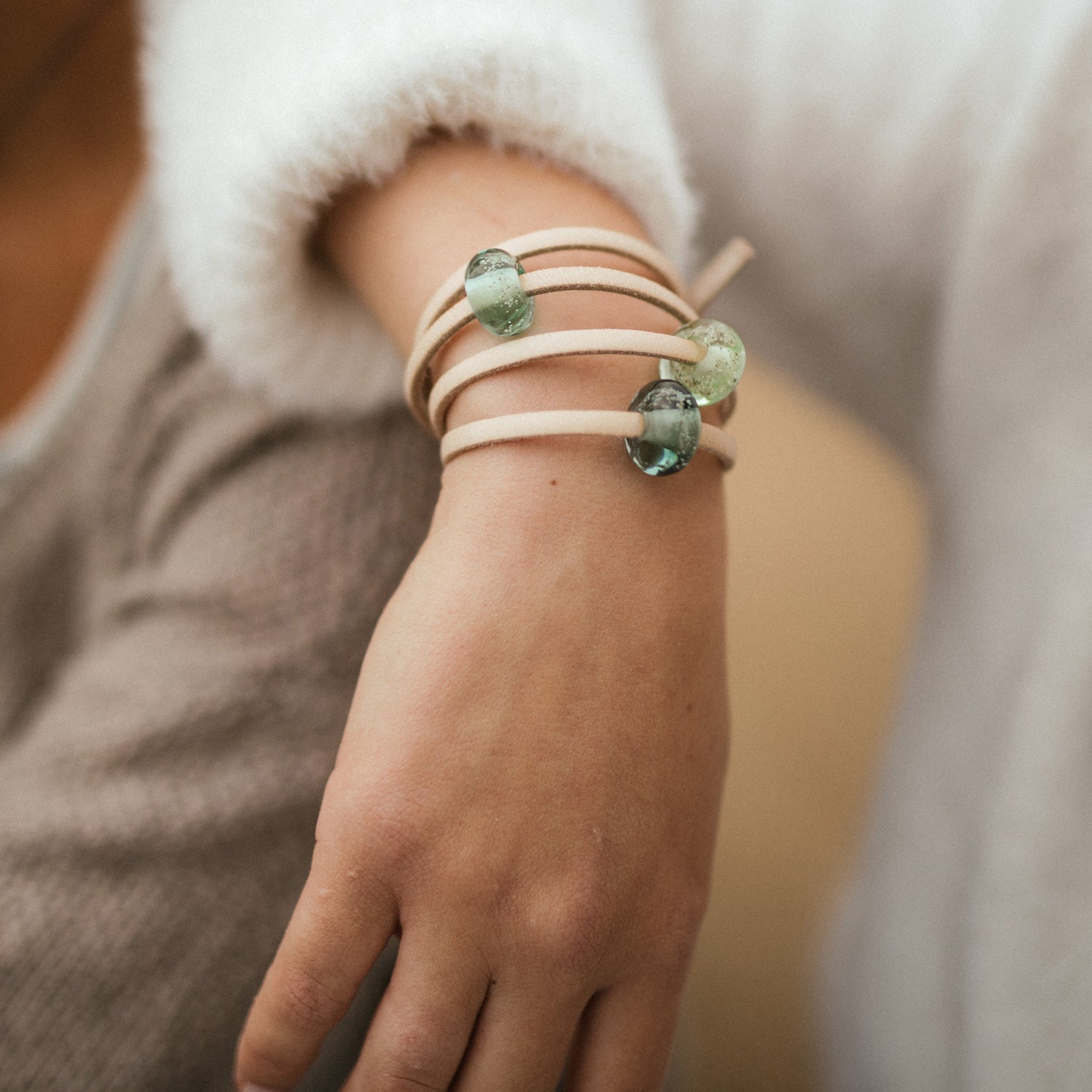 Sand leather wrap with sand beads worn by woman.