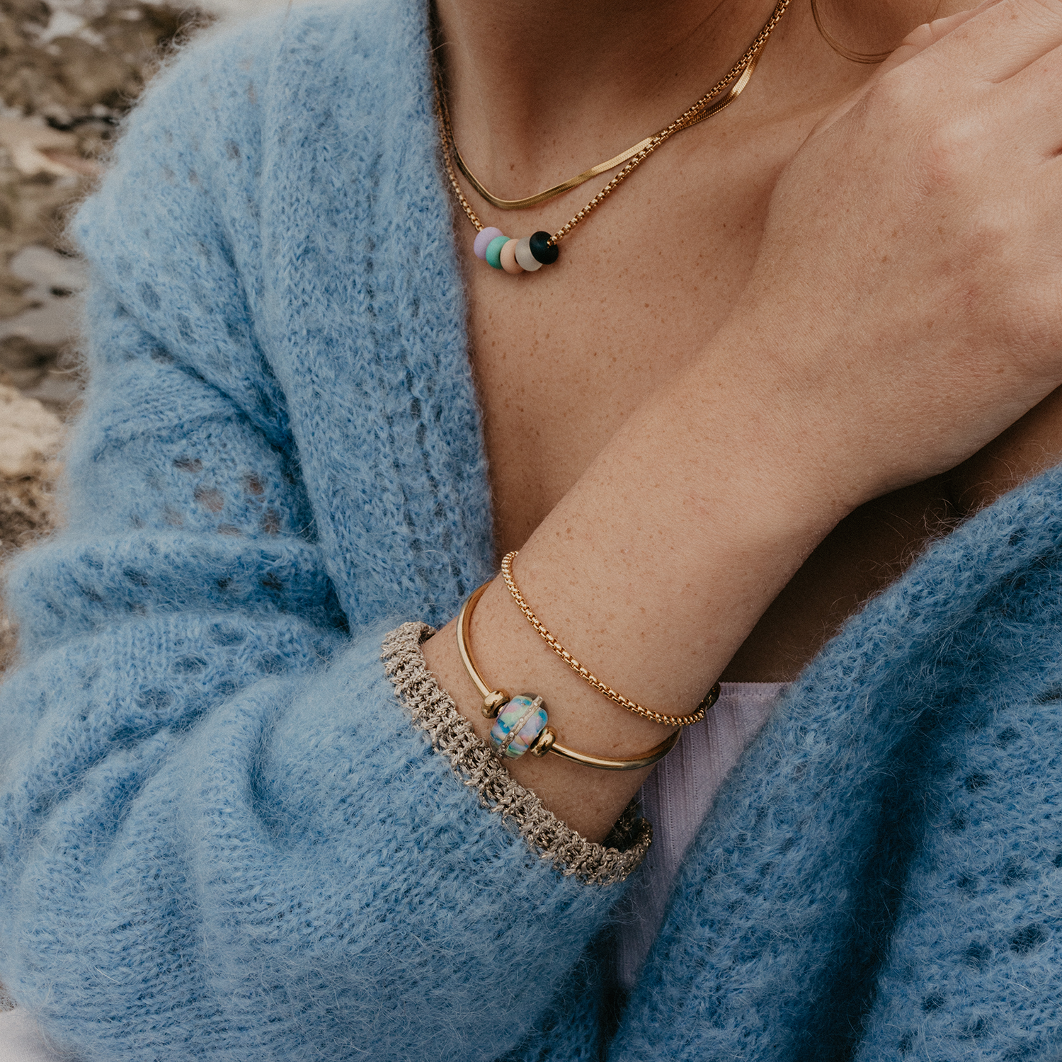 Gold jewellery layers with the Aldeburgh bead on gold bangle.