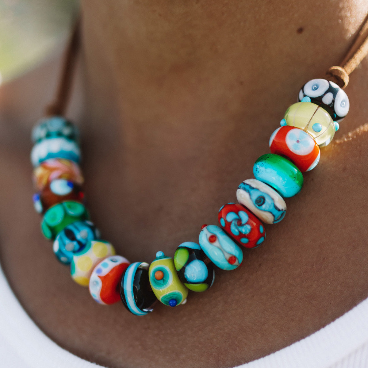 Bright colorful Murano glass beads worn on a cord necklace.