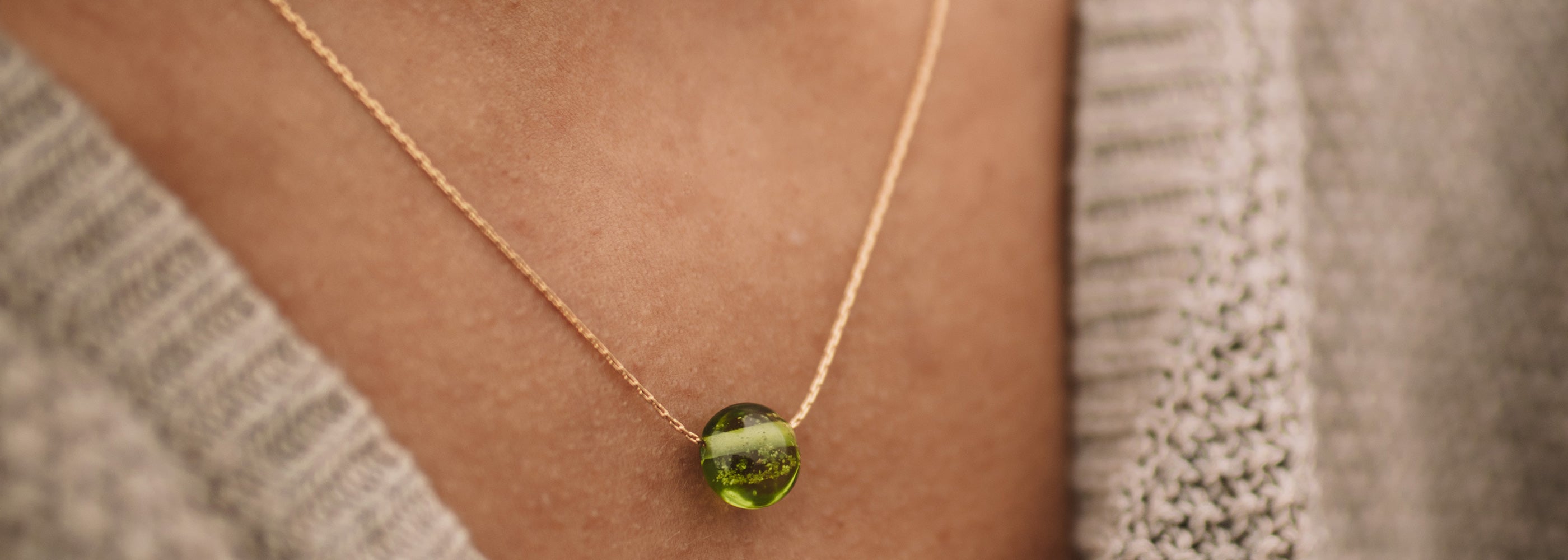 Apple green sand pebble on gold chain necklace.