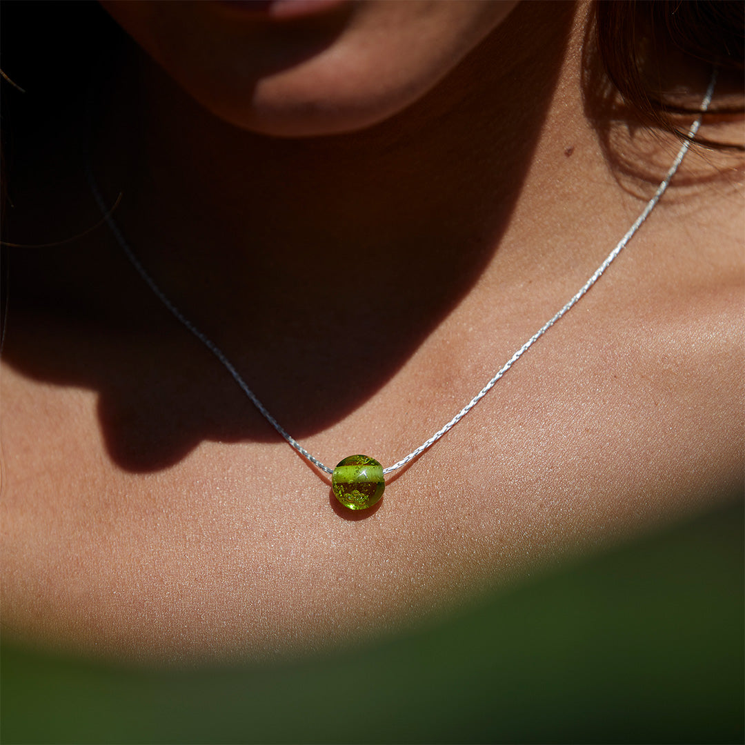 Woman wearing a apple glass pebble necklace.