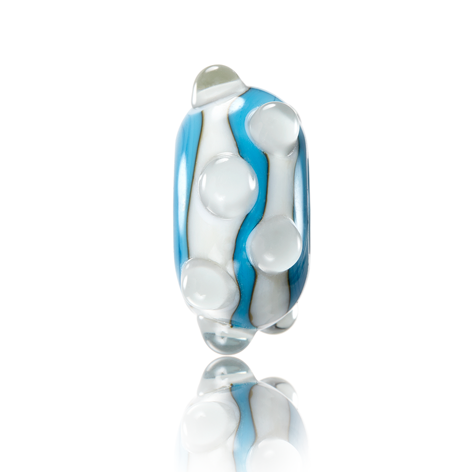 Blue and white striped and spotted glass bead representing Combesgate in Woolacombe North Devon.