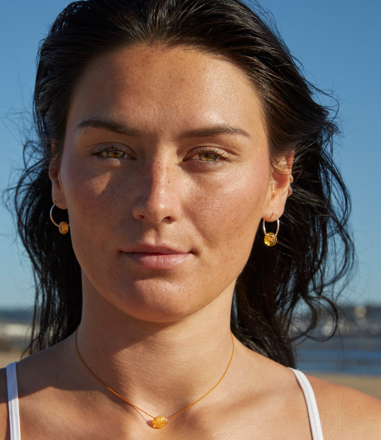 Girl wearing amber glass beads on sterling silver hoop earrings at the beach Crow Point.