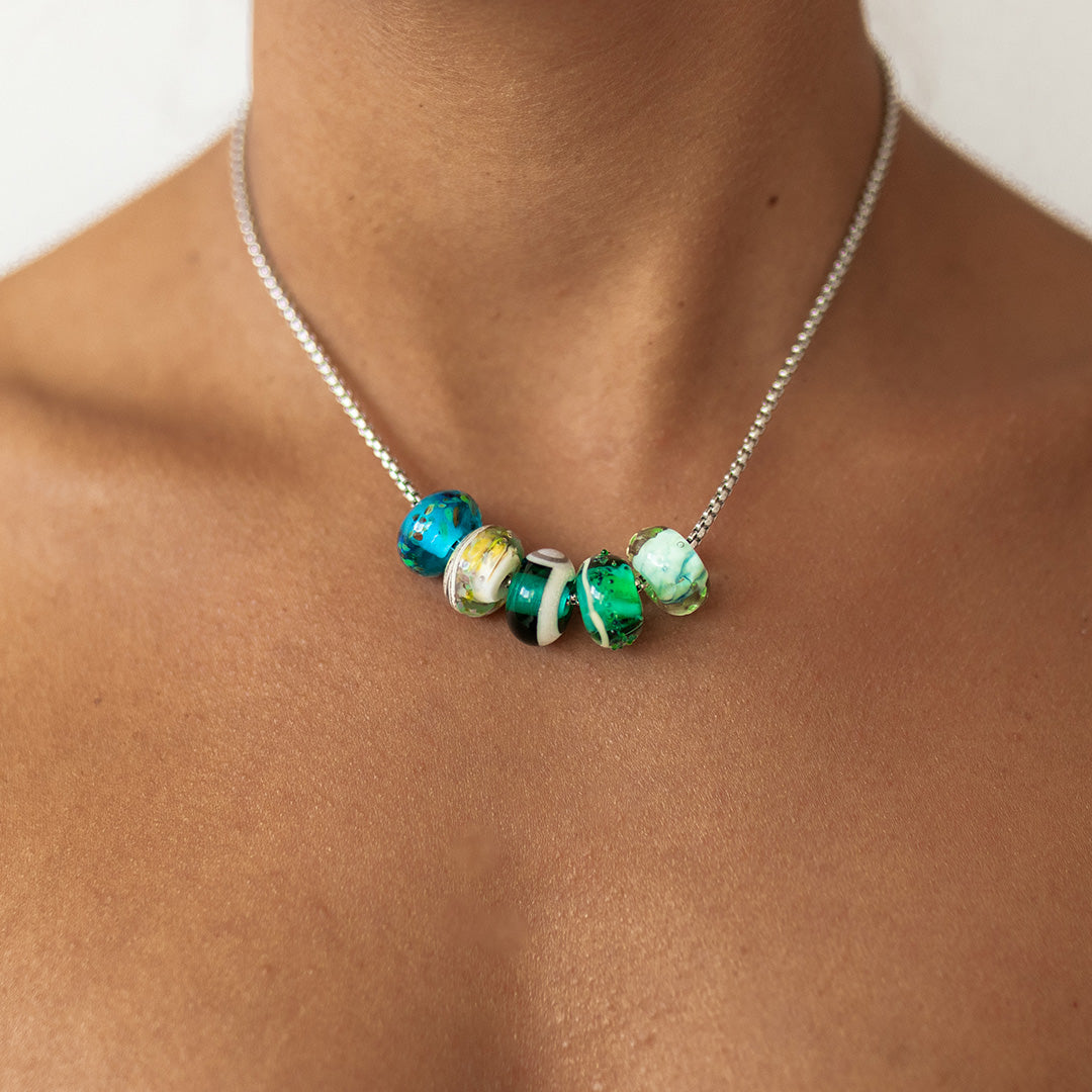 Colourful glass beads on silver Ula necklace worn by woman.