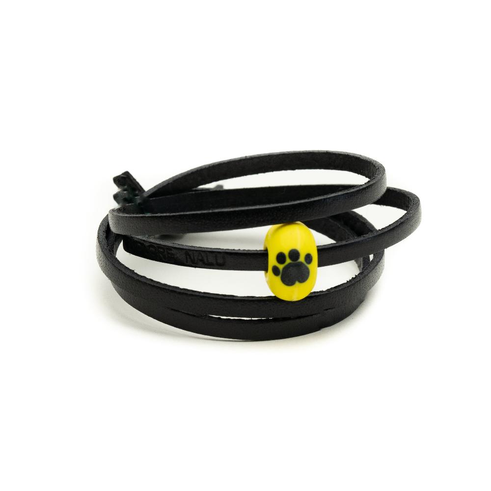 Dogs Trust yellow bead on the black leather wrap.