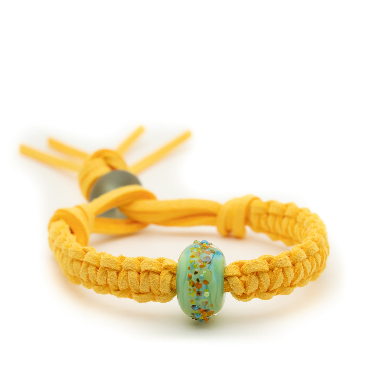 A yellow braided cord bracelet with a central round glass bead featuring a speckled light blue, green, and orange pattern, set against a plain white background.