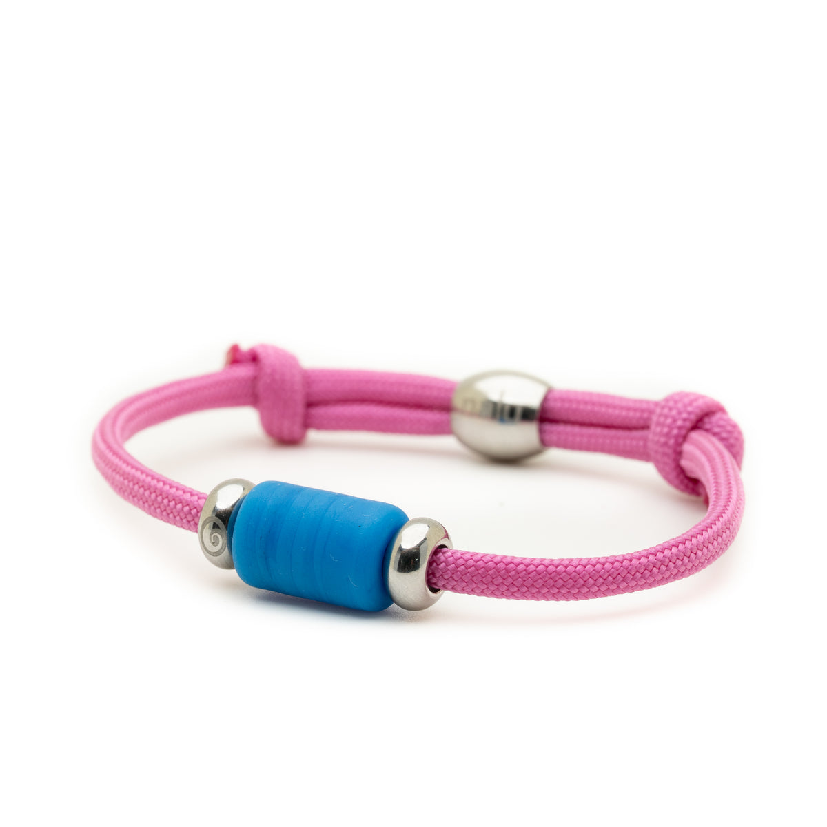 A pink adjustable cord bracelet featuring a central textured blue cylindrical bead and polished silver metal accents, shown on a clean white background.