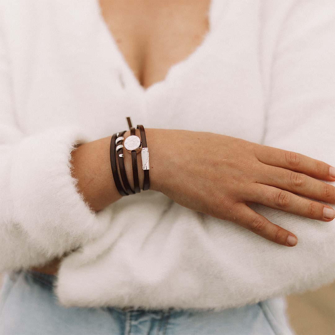 Person wearing a brown and silver wrap bracelet.