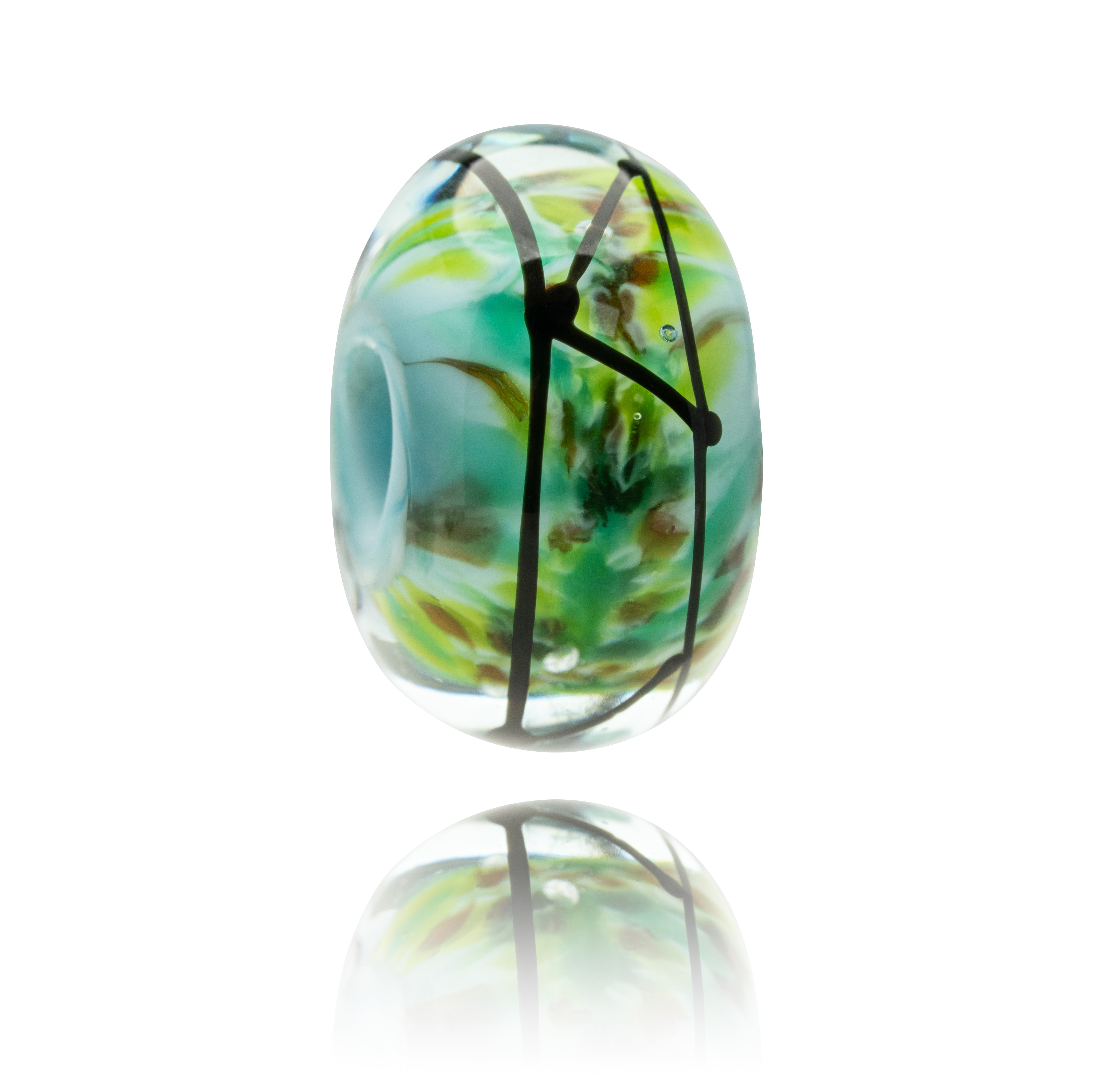 Glass bead with green and black design on a white background