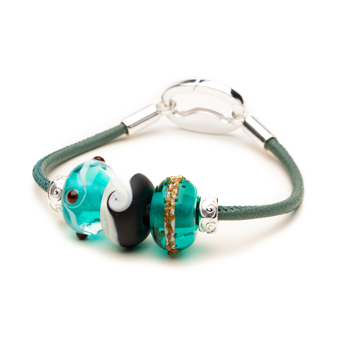 Leather bracelet with blue glass beads and silver charms.