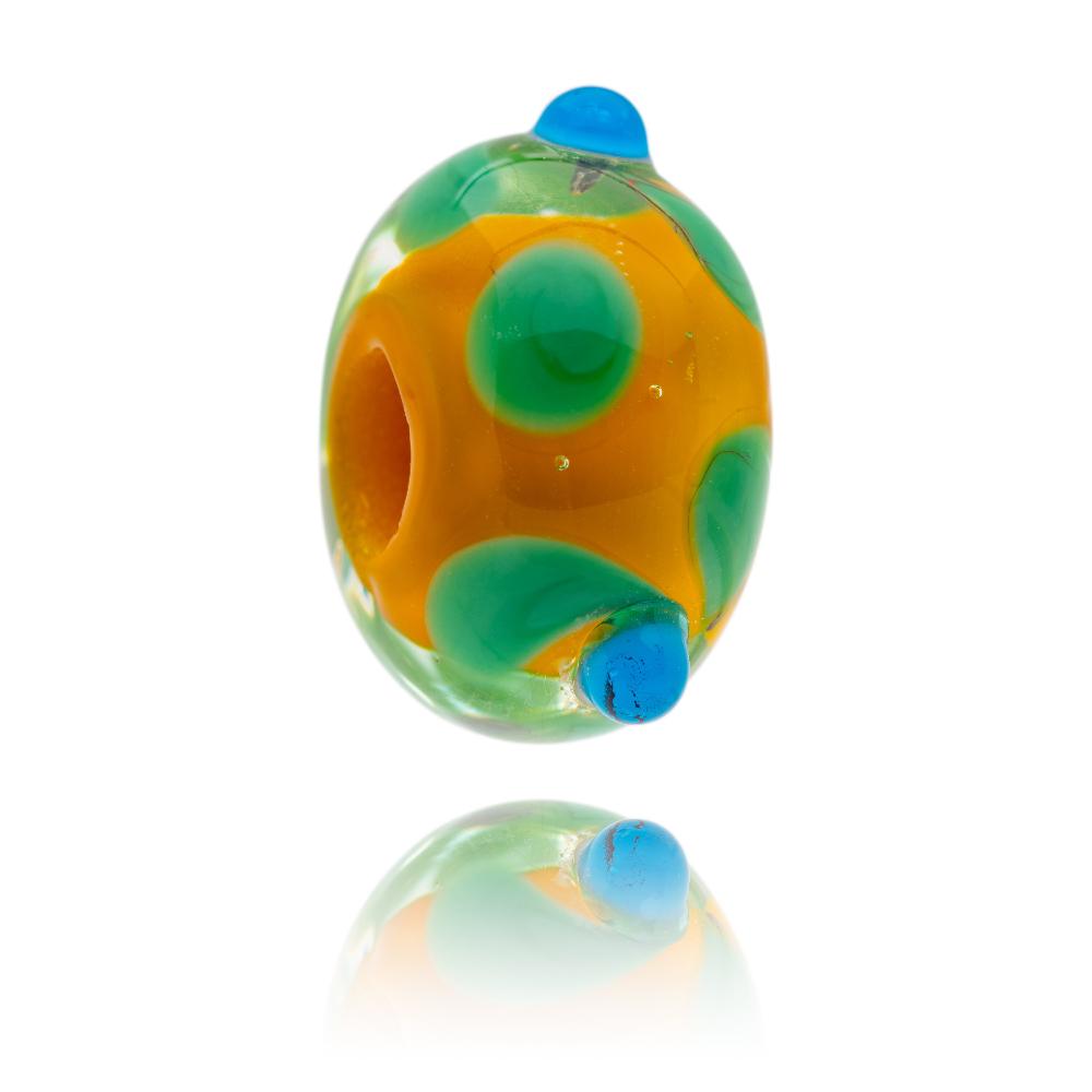 Gold glass bead with green and blue surface petal patterns, designed for the island of Cuba in the Caribbean. 