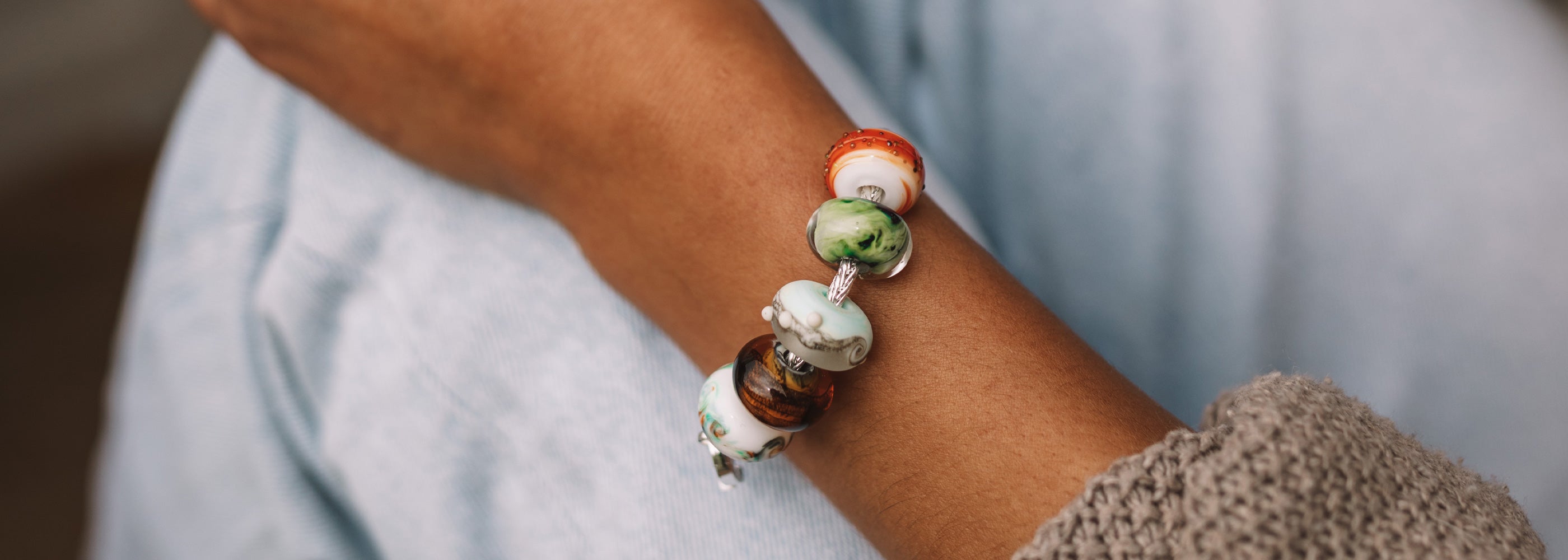 Colourful glass beads worn on sterling silver bracelet.