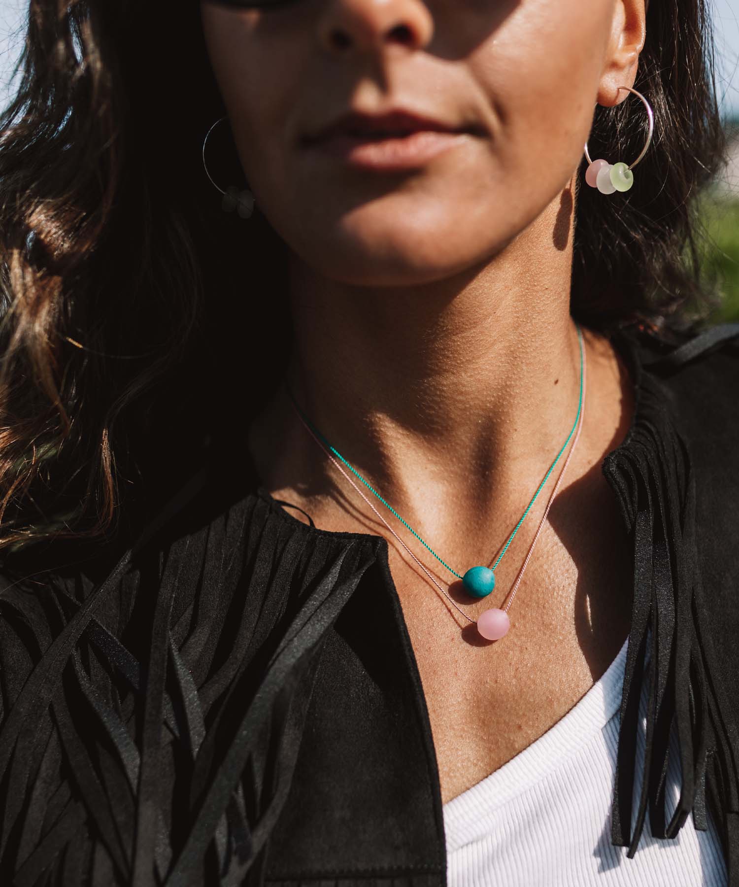 Woman wearing colourful beaded necklaces and earrings.