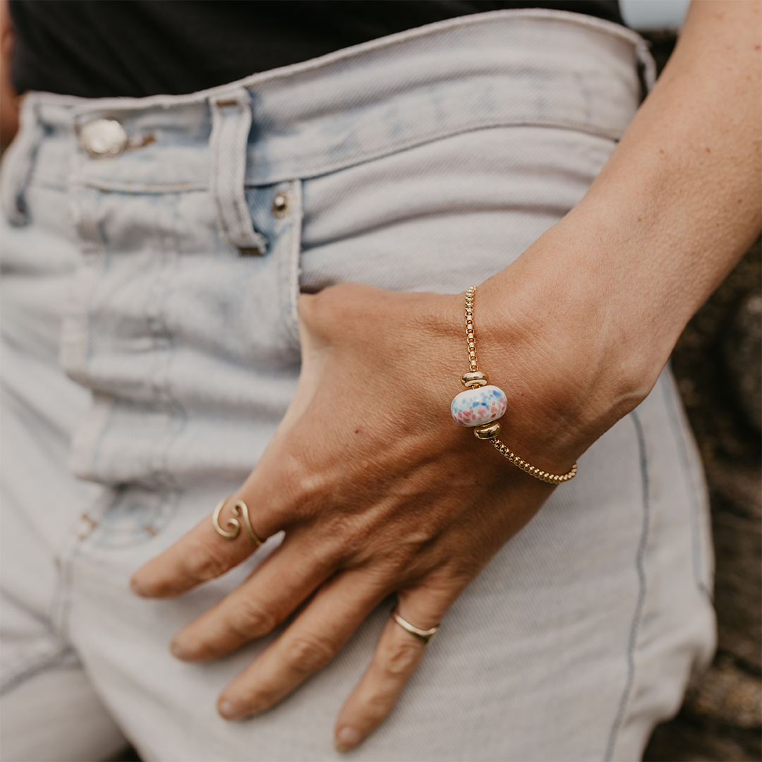 CEO of Plastic Free North Devon wearing a PFND charity bead on gold bracelet.