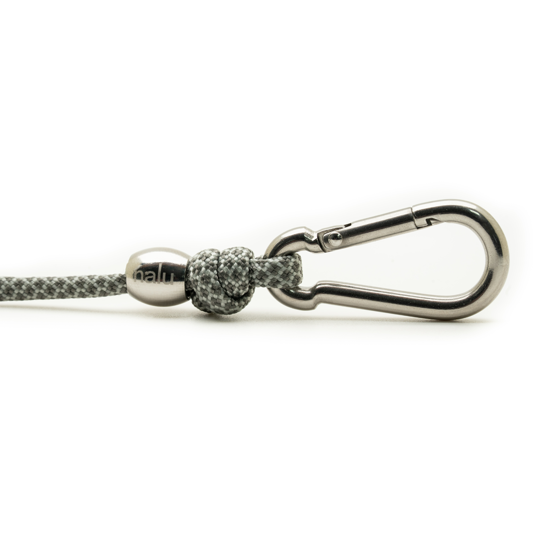 Metal carabiner with textured ball and rope on a white background