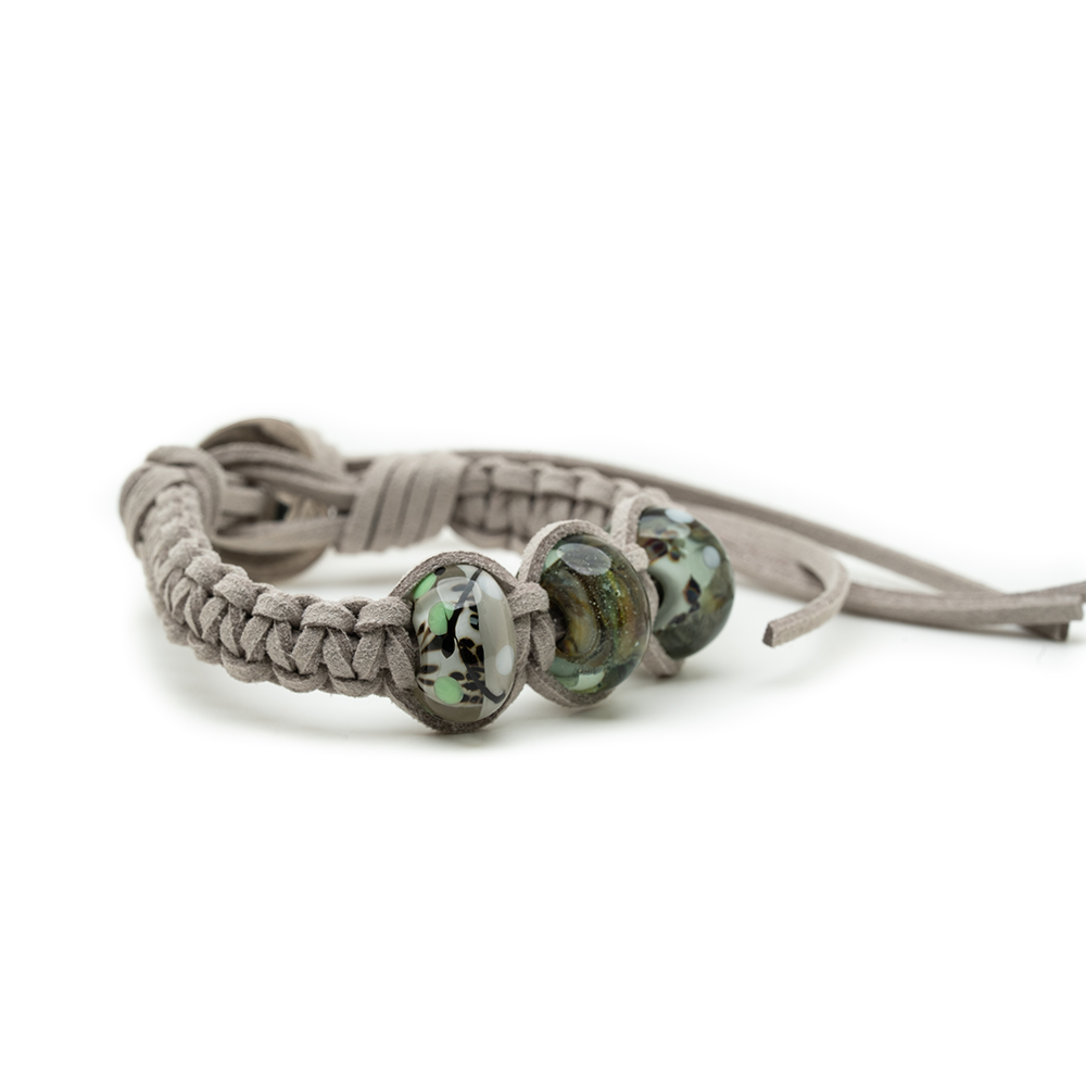 Bracelet with braided design and three beads on a white background