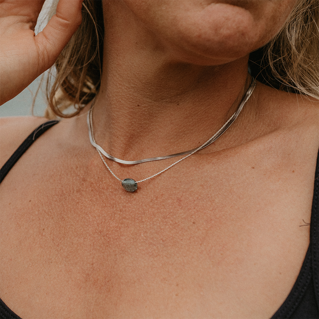 Person wearing silver necklace.