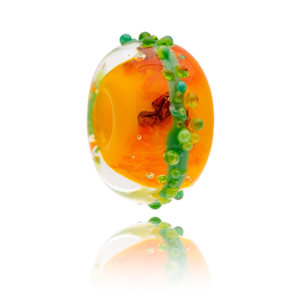 Bright orange glass bead with green surf dots representing Jamaica.