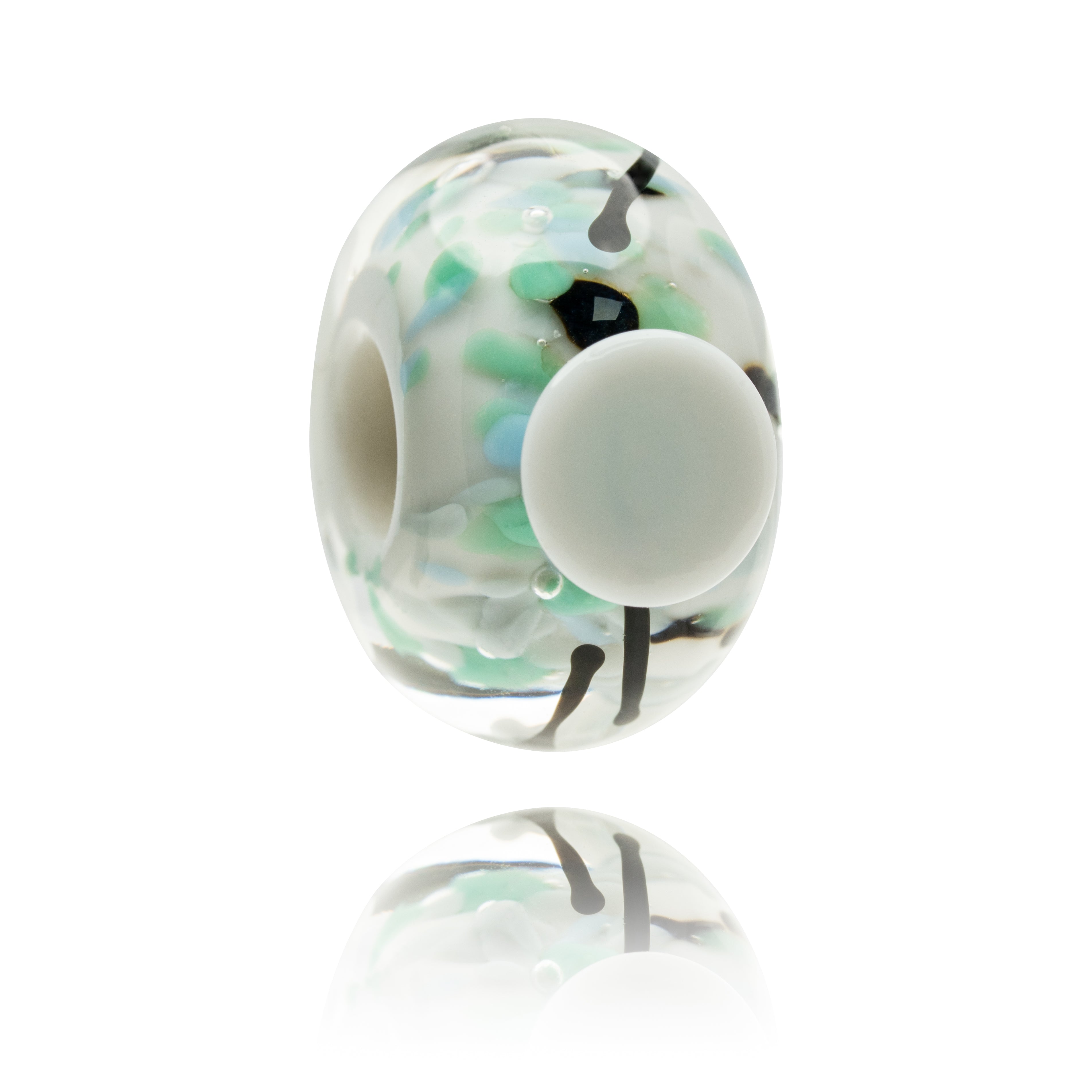 White glass bead with speckles of green and blue within it and a white dot on the surface.