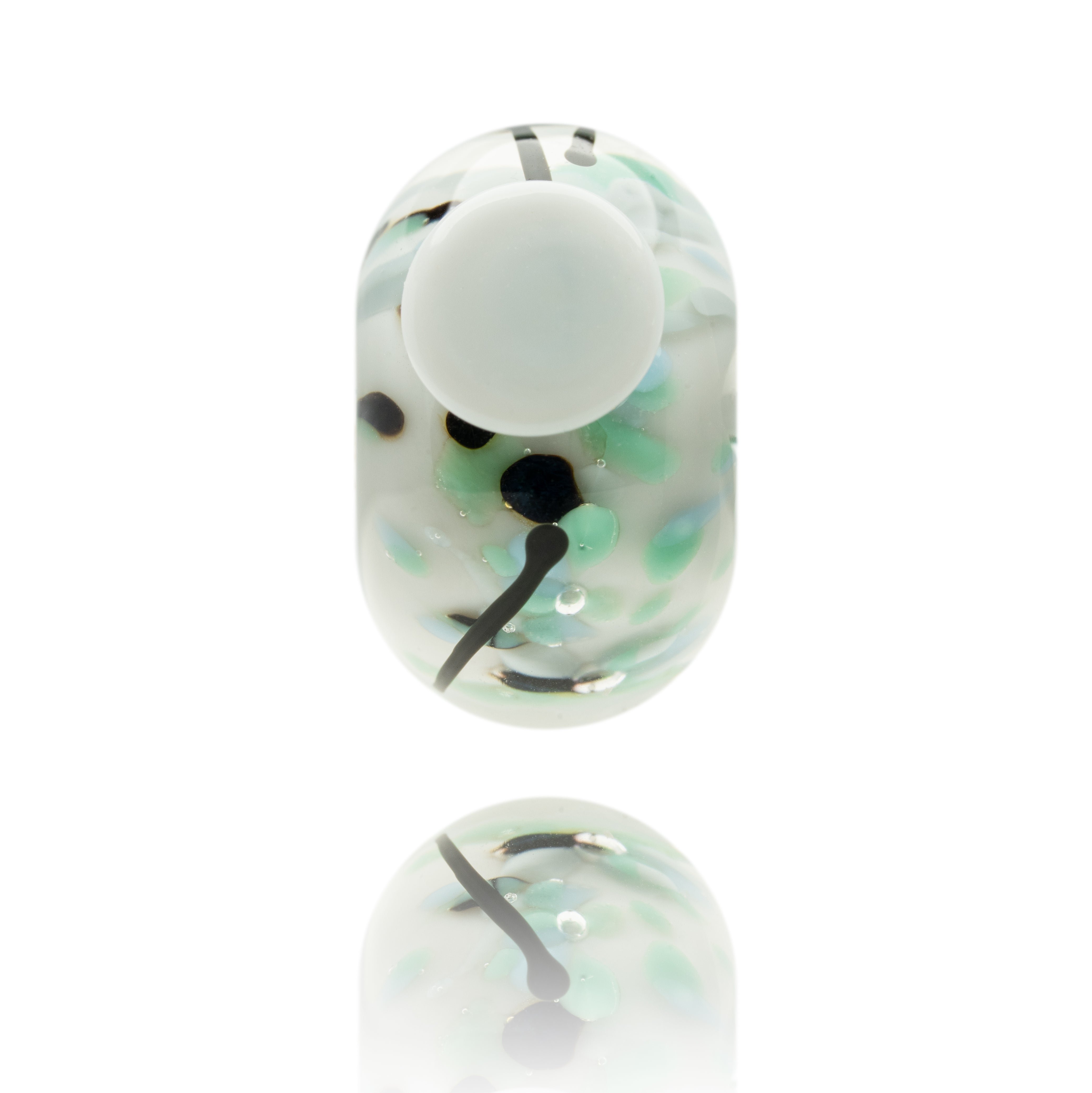 White glass bead with speckles of green and blue within it and a white dot on the surface.