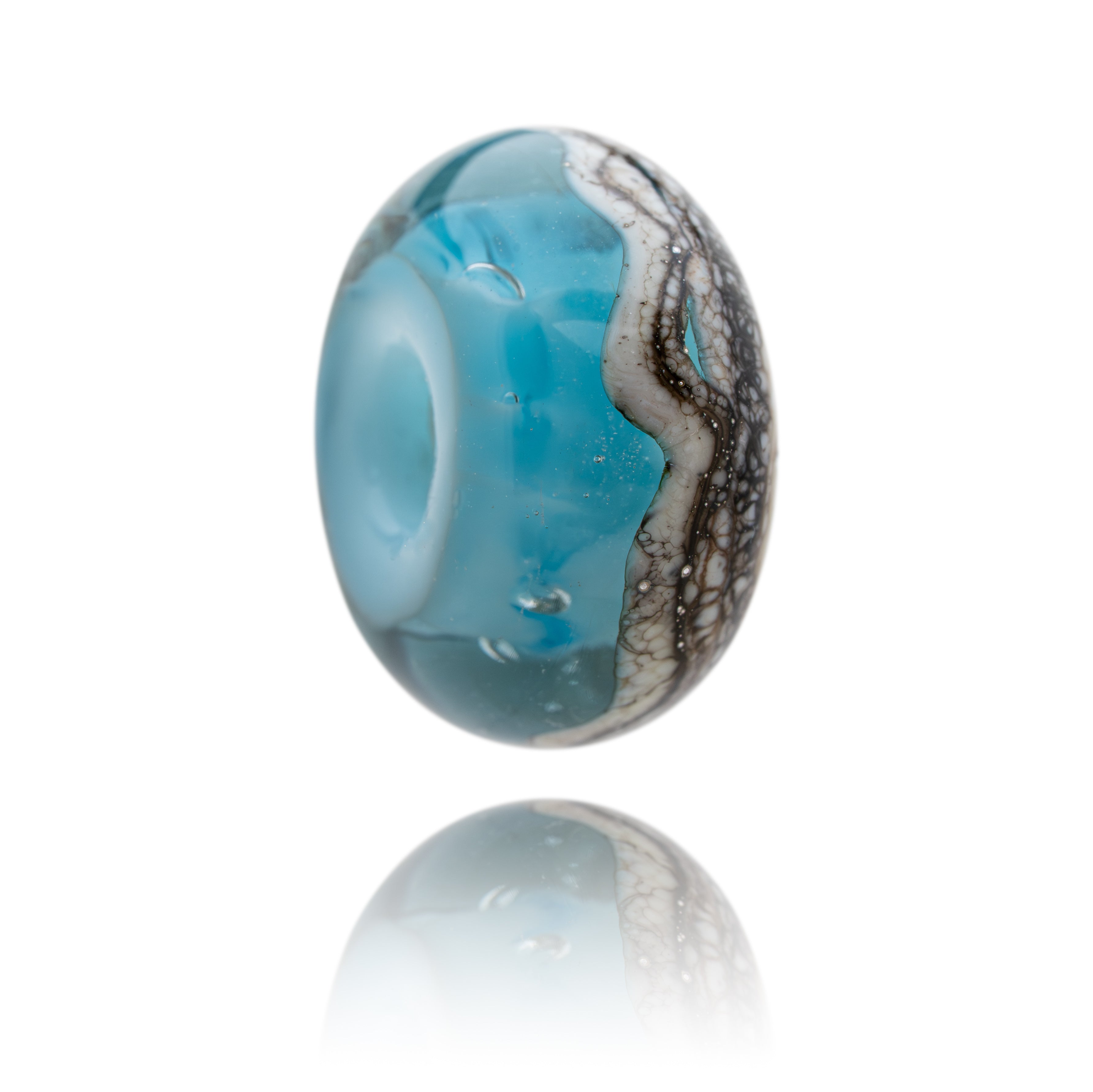 Glass bead with blue and silver design on a white background