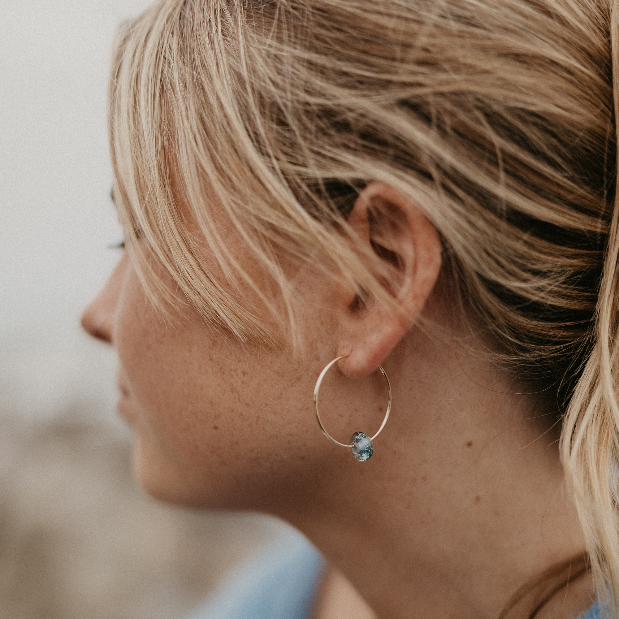 Large gold beach drop hoop beaded earring.