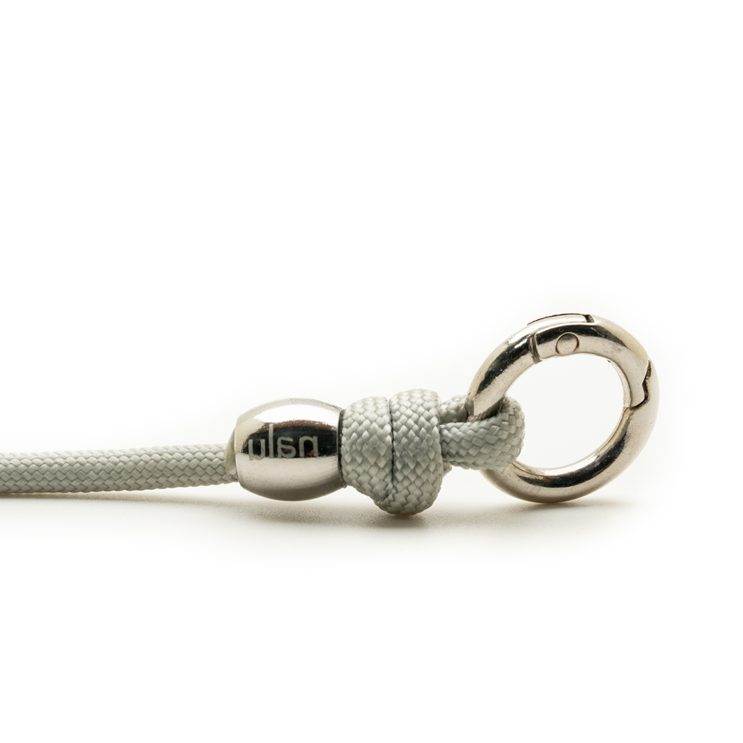 Close-up of a silver clasp with a rope on a white background