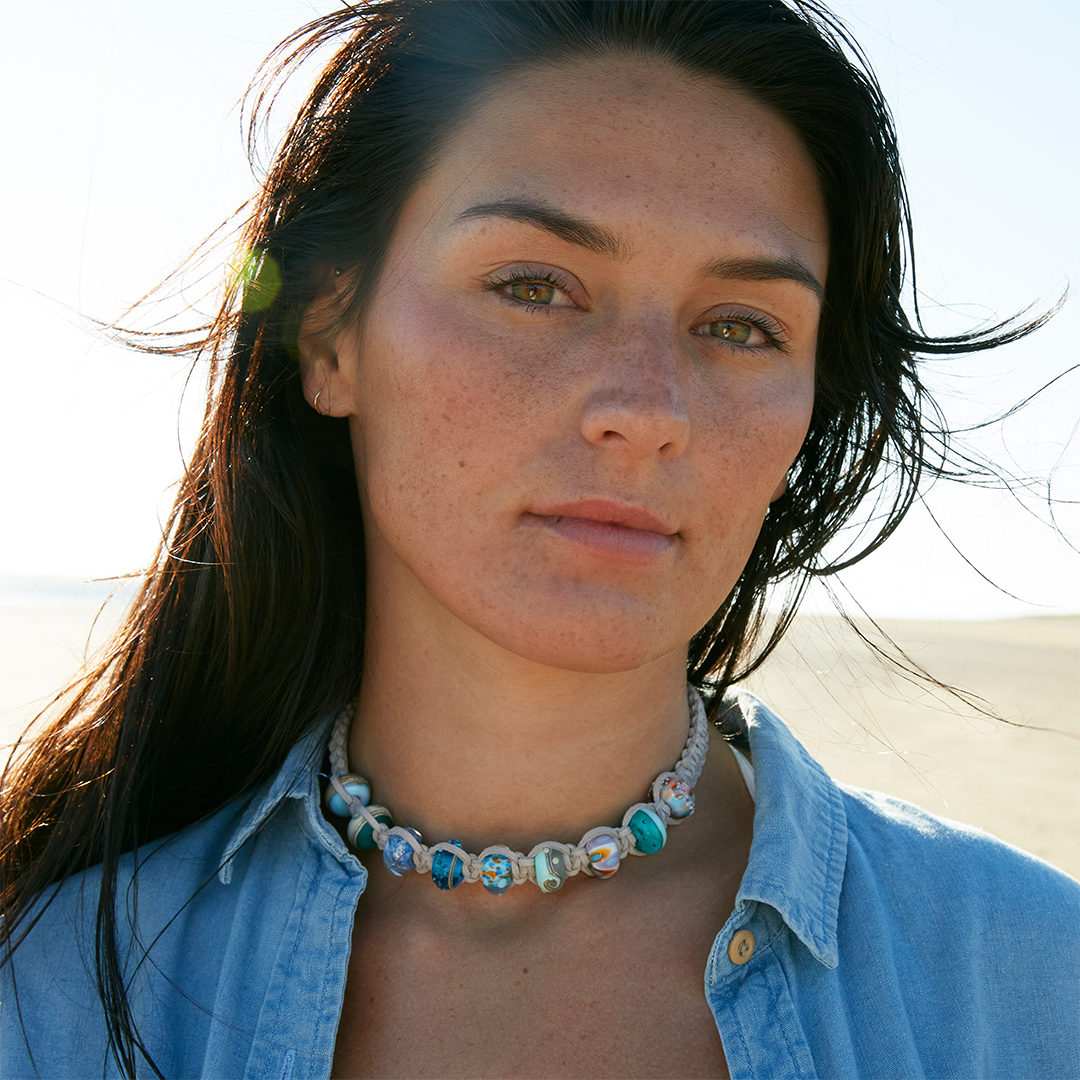 Woman with denim top wearing grey cord choker necklace with colorful glass beads in North Devon.