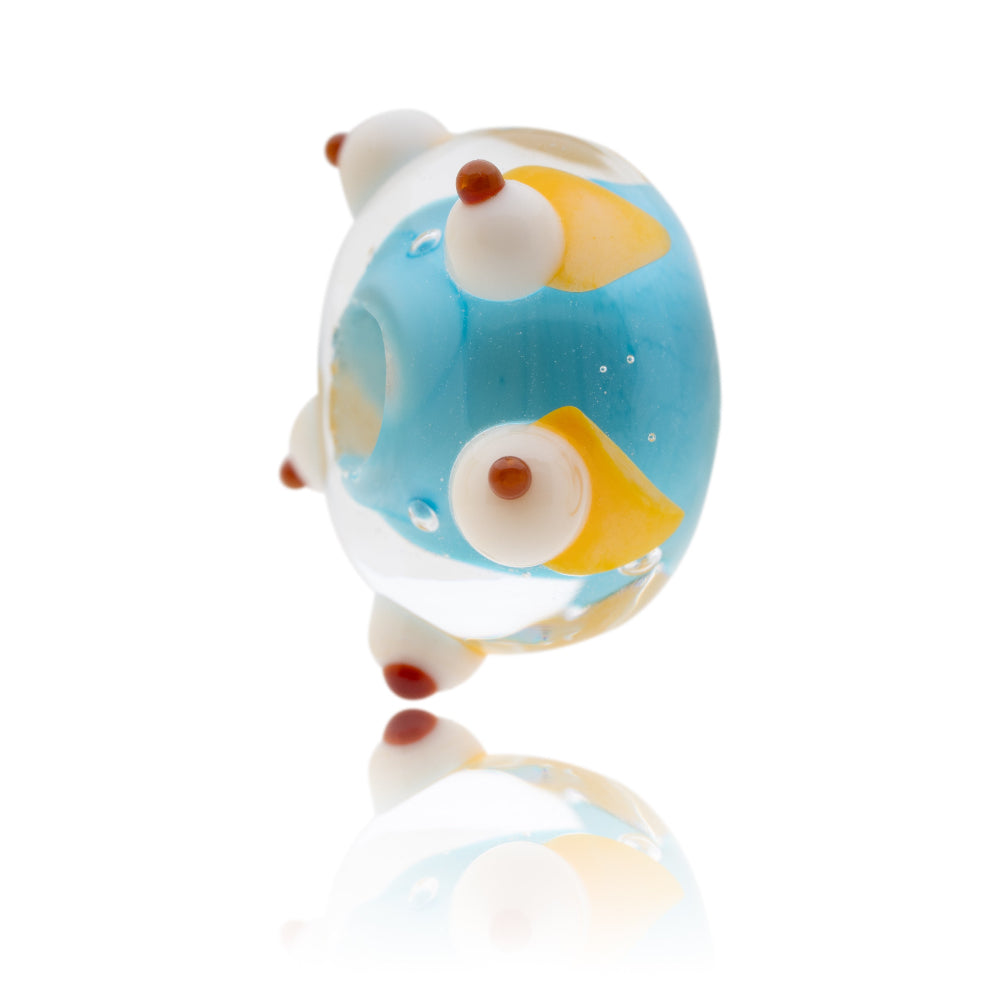 Turquoise and clear glass bead with cream cones decorations around the out side.