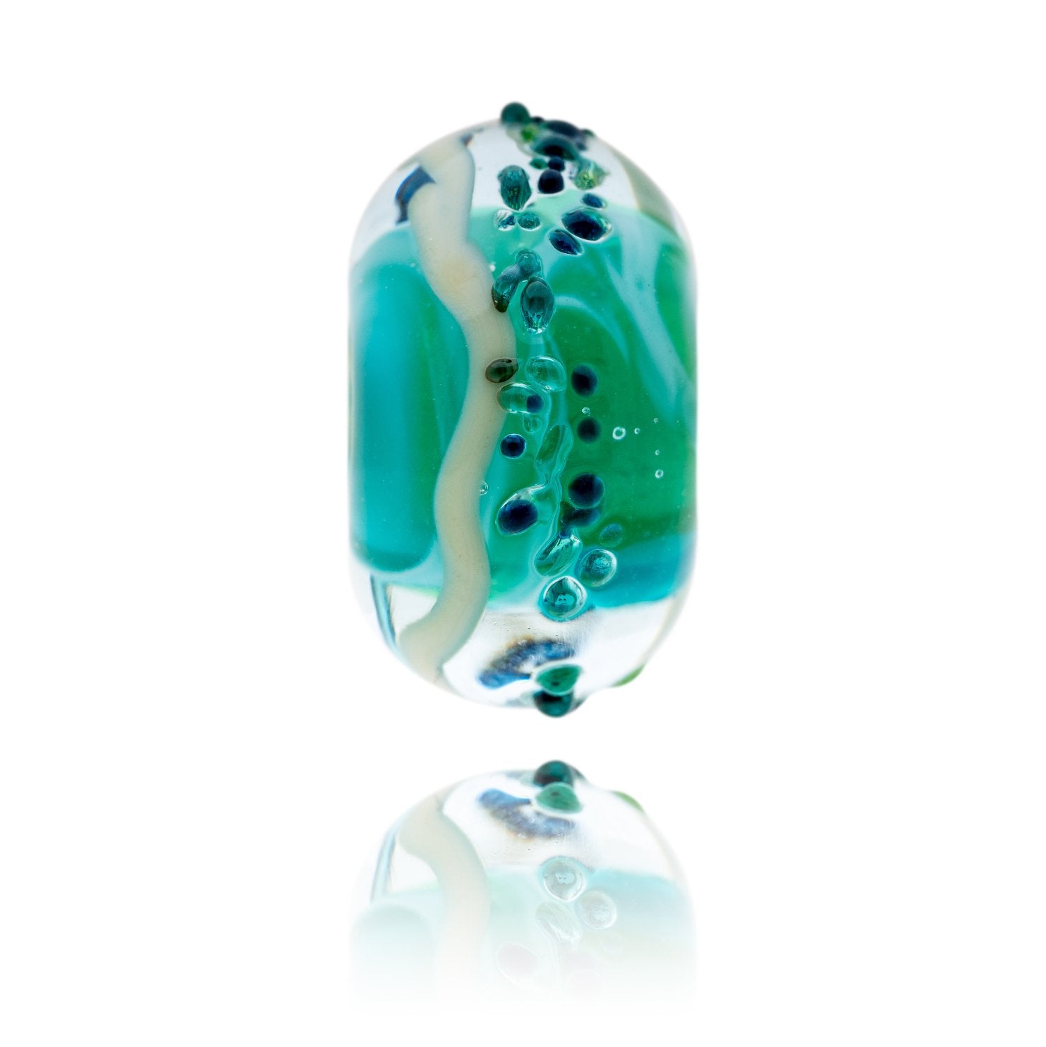 A glass bead with a swirling green core, with clear outside and specks of green and blue on the surface. Representing Mill Bay in South Devon.