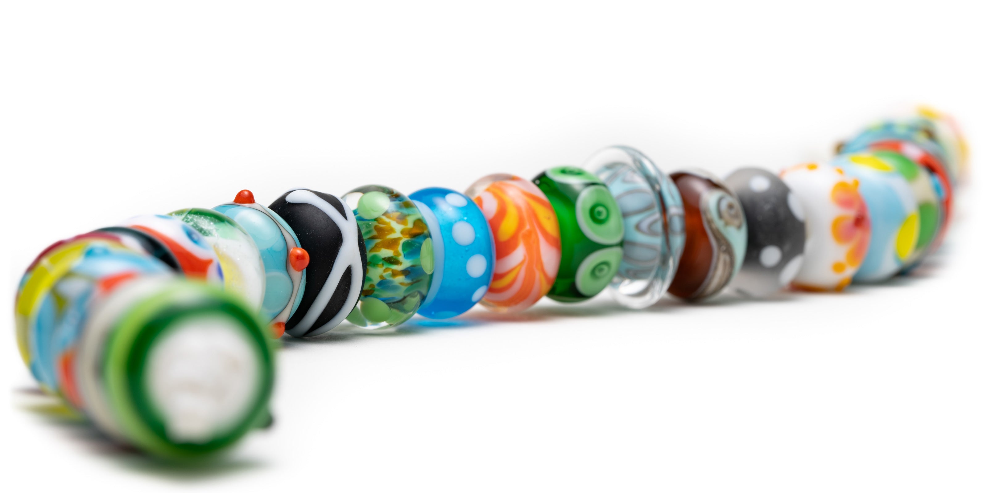 Bright, colourful Murano glass beads in a row.