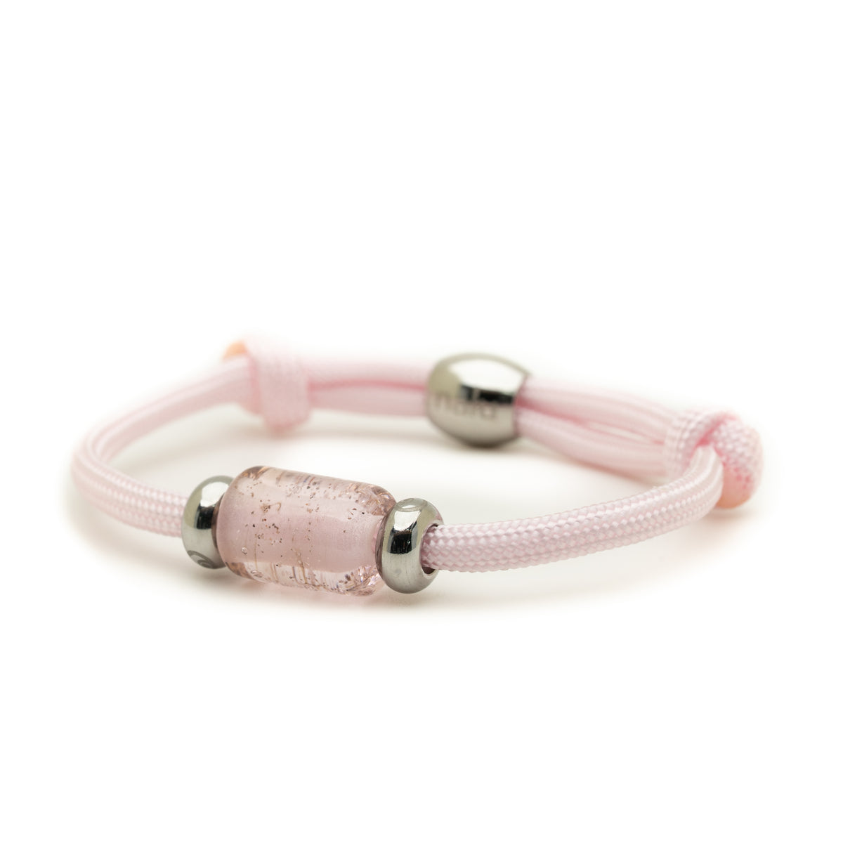 A light pink braided cord bracelet featuring a central textured, translucent pink glass bead flanked by polished silver metal spacers, shown on a clean white background.