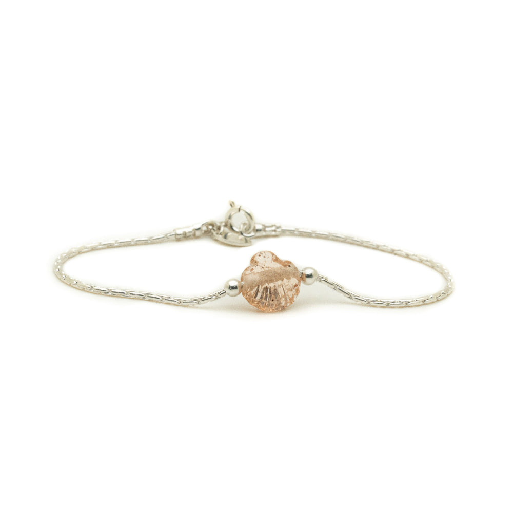Silver bracelet with a shell-shaped charm on a white background