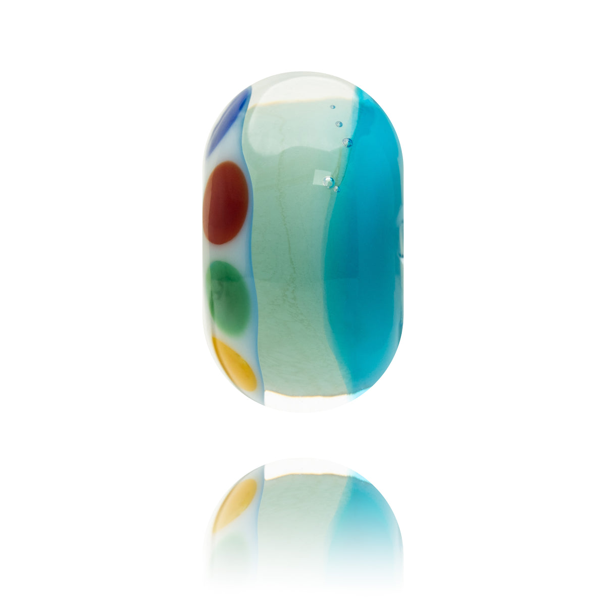 A single handmade glass lampwork bead with a rounded rectangular shape, featuring a light mint green base with a large turquoise blue section on the right, and three colorful circular dots in red, green, and yellow on the left. The bead is shown floating above a clean white surface with a soft reflection below.