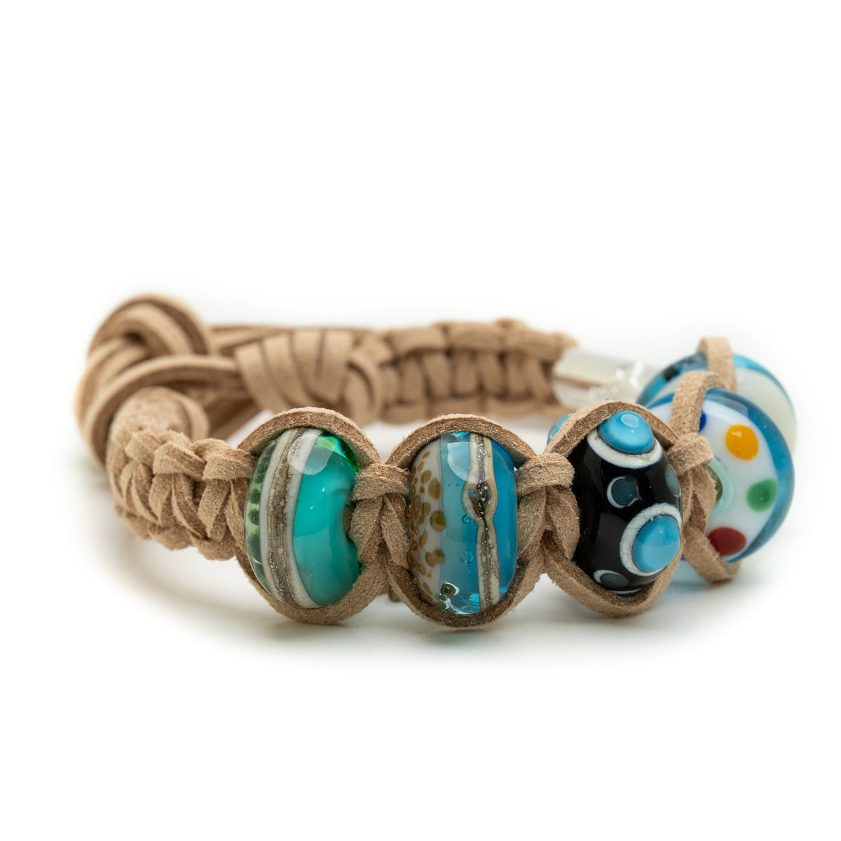 A handmade braided leather bracelet with three large decorative glass beads in turquoise, blue, and black with colorful dots, on a white background.