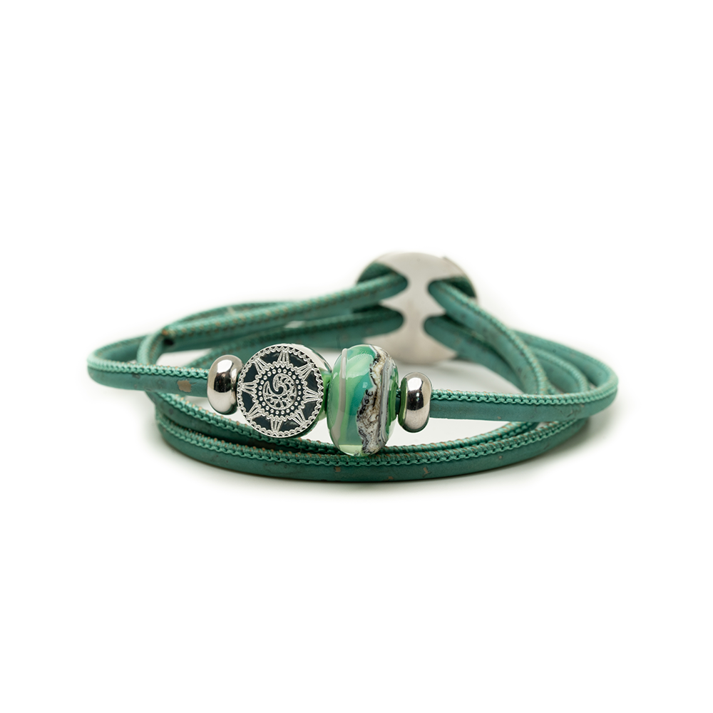 Turquoise leather bracelet with silver and green beads on a white background