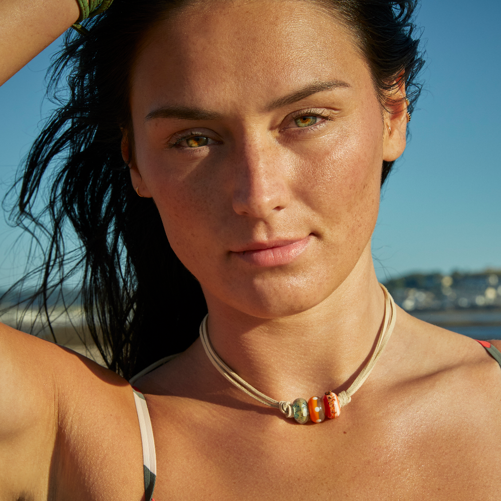 Woman on the beach at Crow Pint, North Devon wearing a cord choker necklace with glass beads.