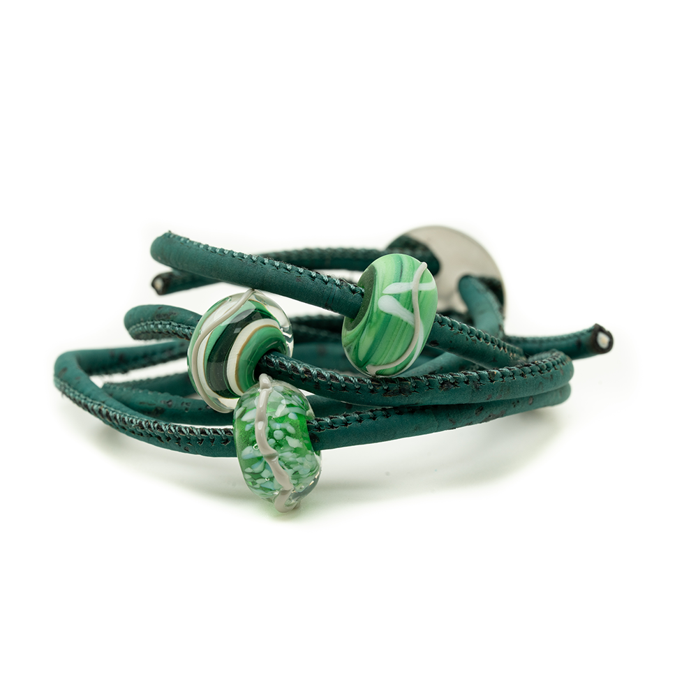 Green bracelet with decorative beads on a white background