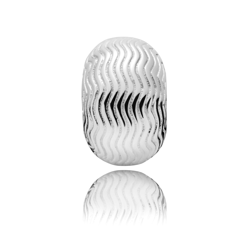 A silver oval charm bead with a textured wavy pattern, shown on a reflective white surface.
