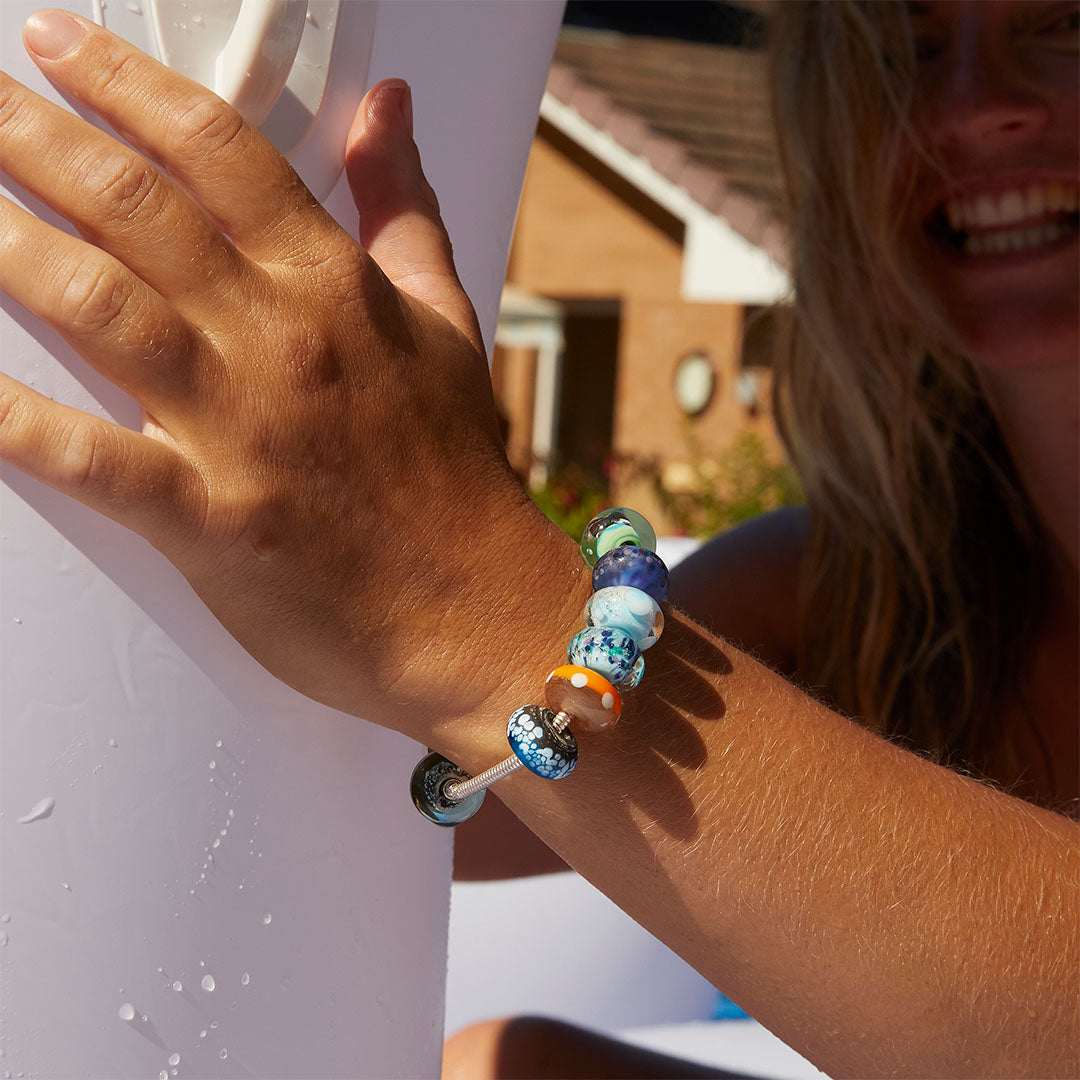 Woman wearing a silver beaded bracelet in the pool.