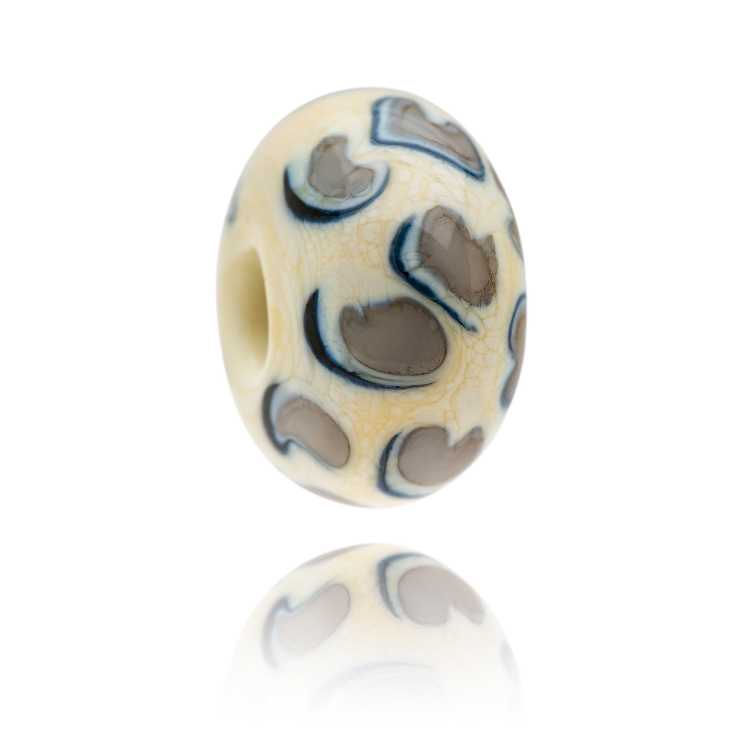 Cream, grey and black glass bead representing snow leopard being sold to raise funds for the World Wildlife Foundation.