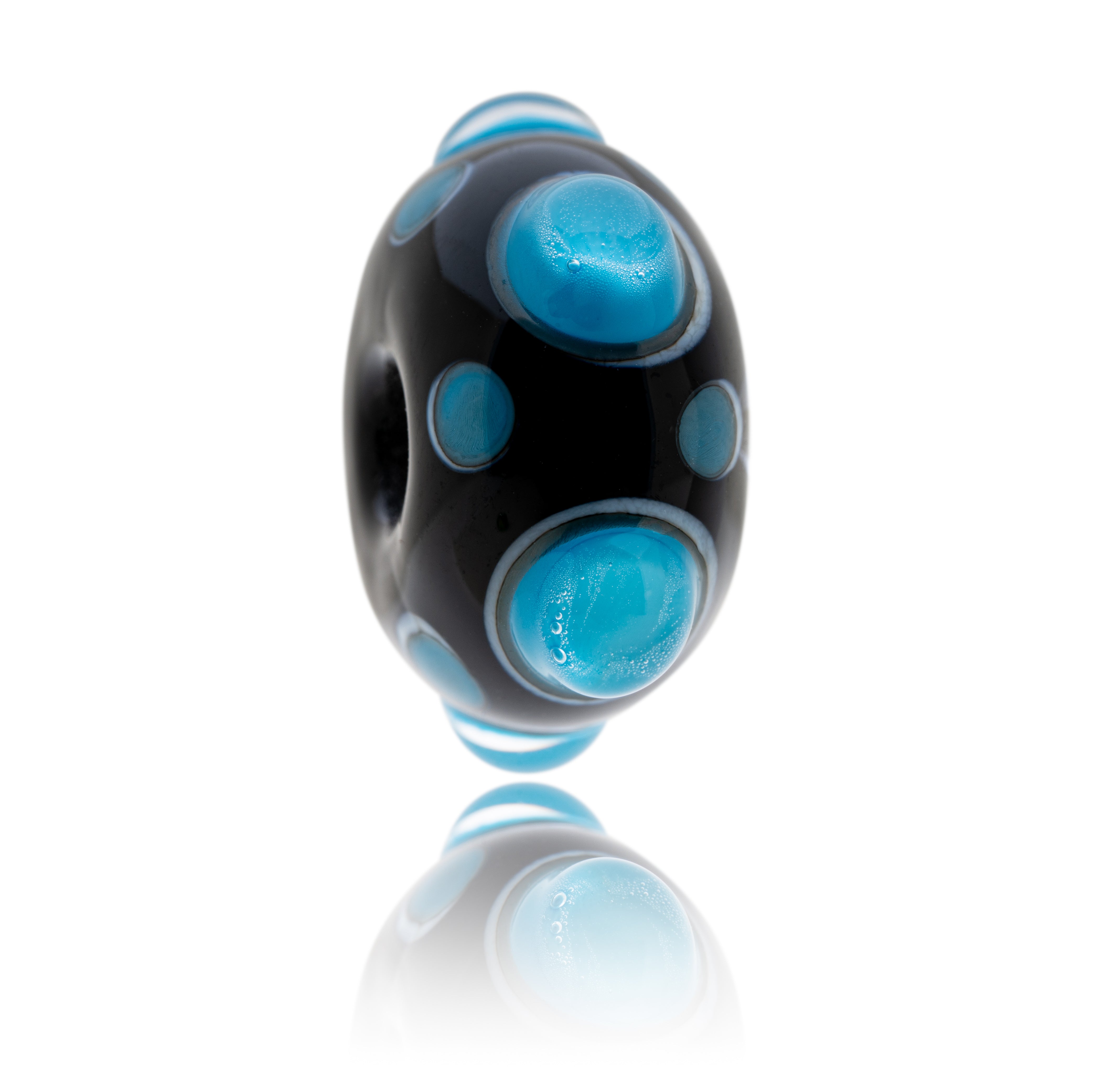 Dark navy blue glass bead with white and blue raised dots on the surface, representing St Ives in Cornwall.