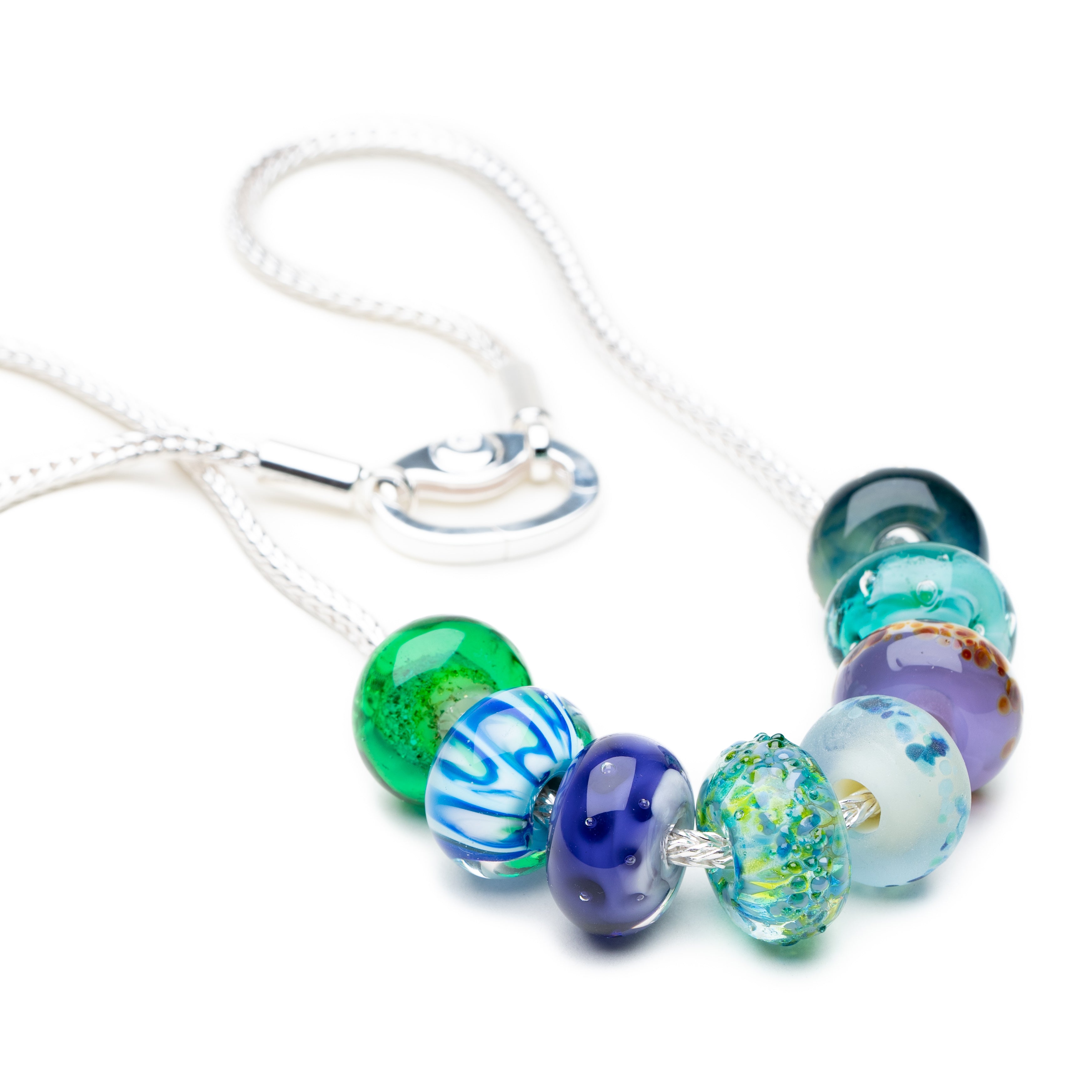 Silver necklace with lamp work glass beads representing Cornish beaches.