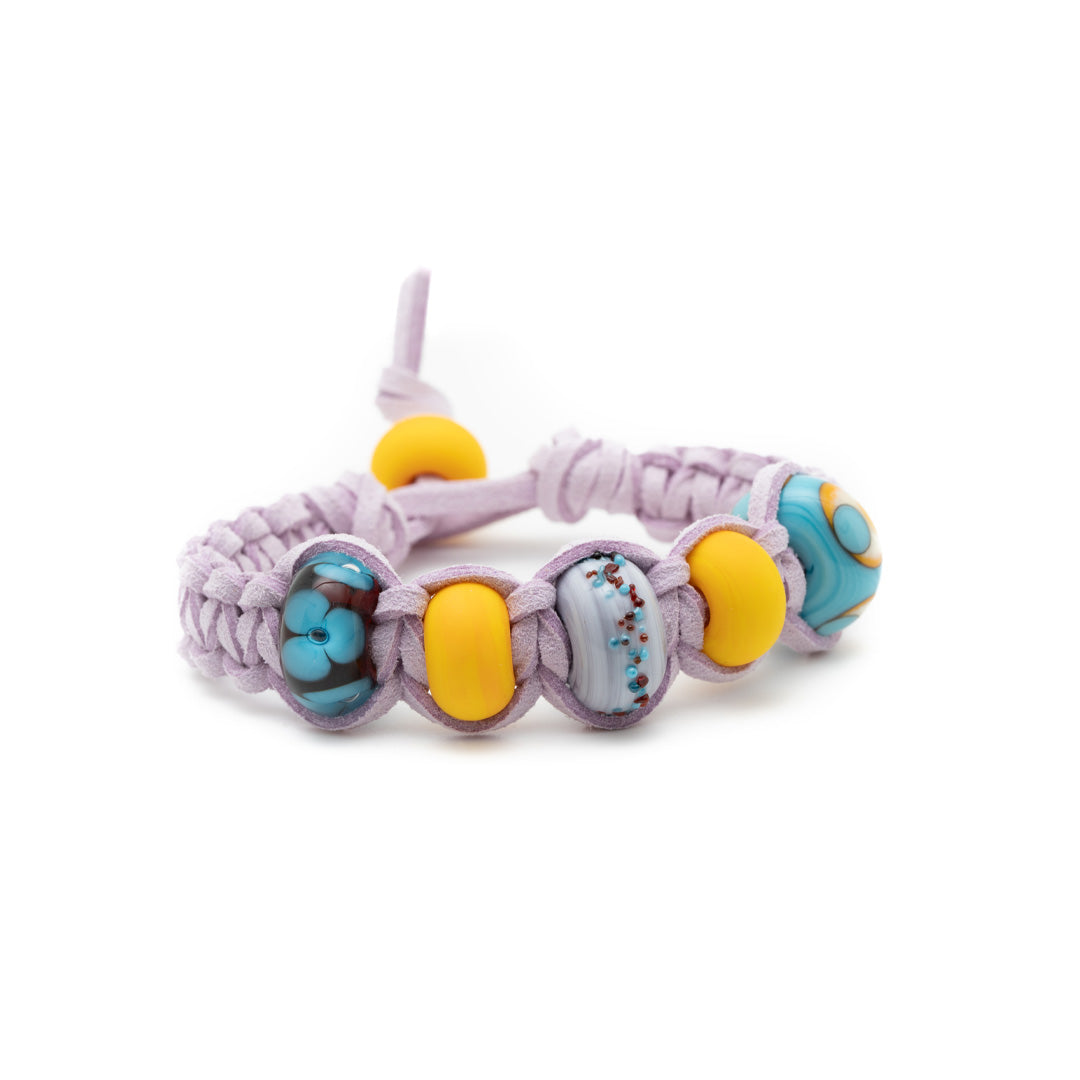 Thistle cord bracelet with yellow and blue glass beads.