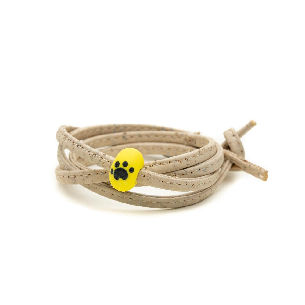 Dogs Trust yellow bead on the white cork wrap.