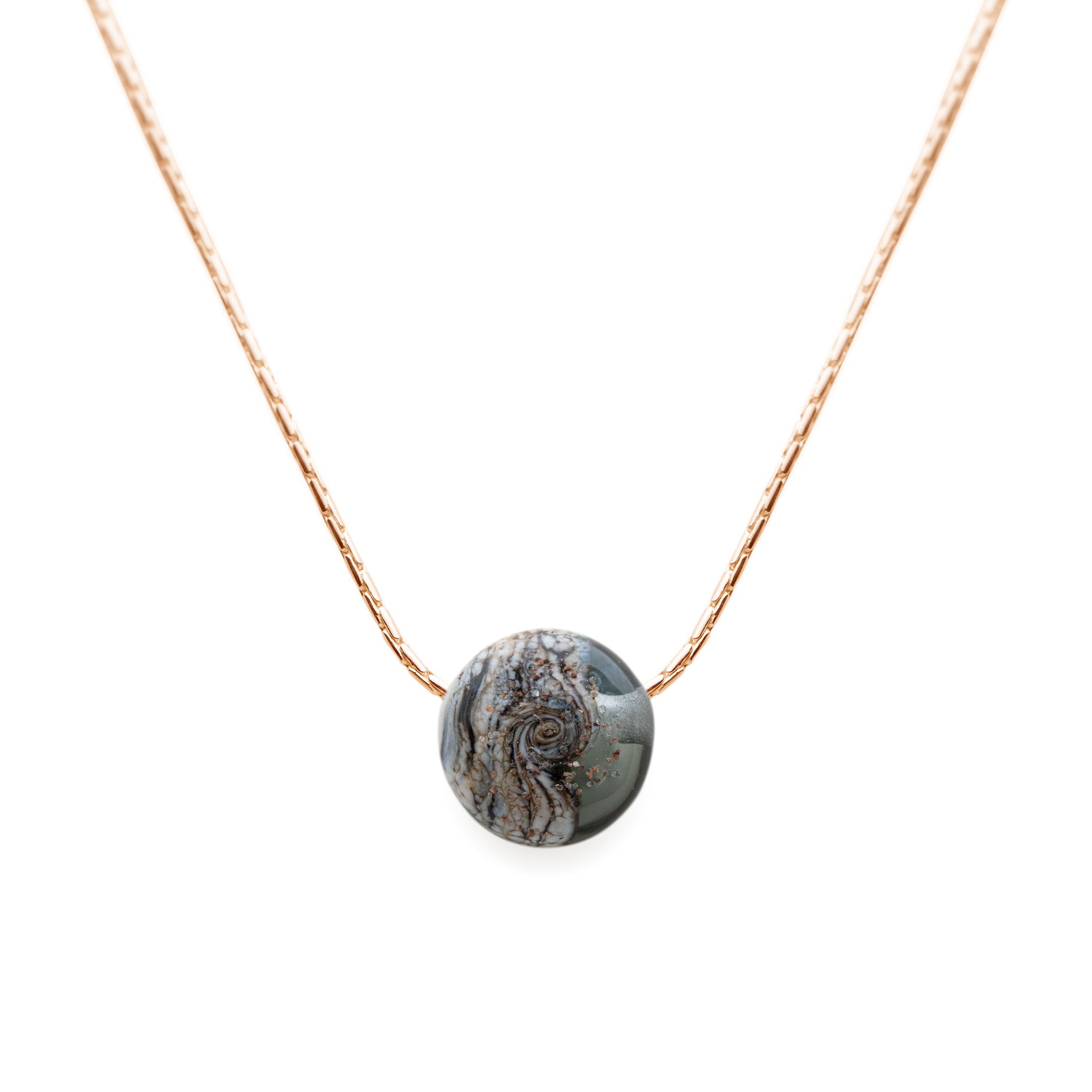 Necklace with a round, textured pendant on a white background